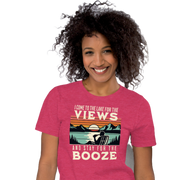 Tee showing "I Come to the Lake for the Views and Stay for the Booze," with a man in a beach chair, lake, and retro sunset.