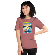 Tee with "Lake Days Are Made for Sipping and Dipping," featuring a woman on a tube float with a cocktail, lake and sunset backdrop.