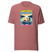 Tee with "Lake Days Are Made for Sipping and Dipping," featuring a woman on a tube float with a cocktail, lake and sunset backdrop.