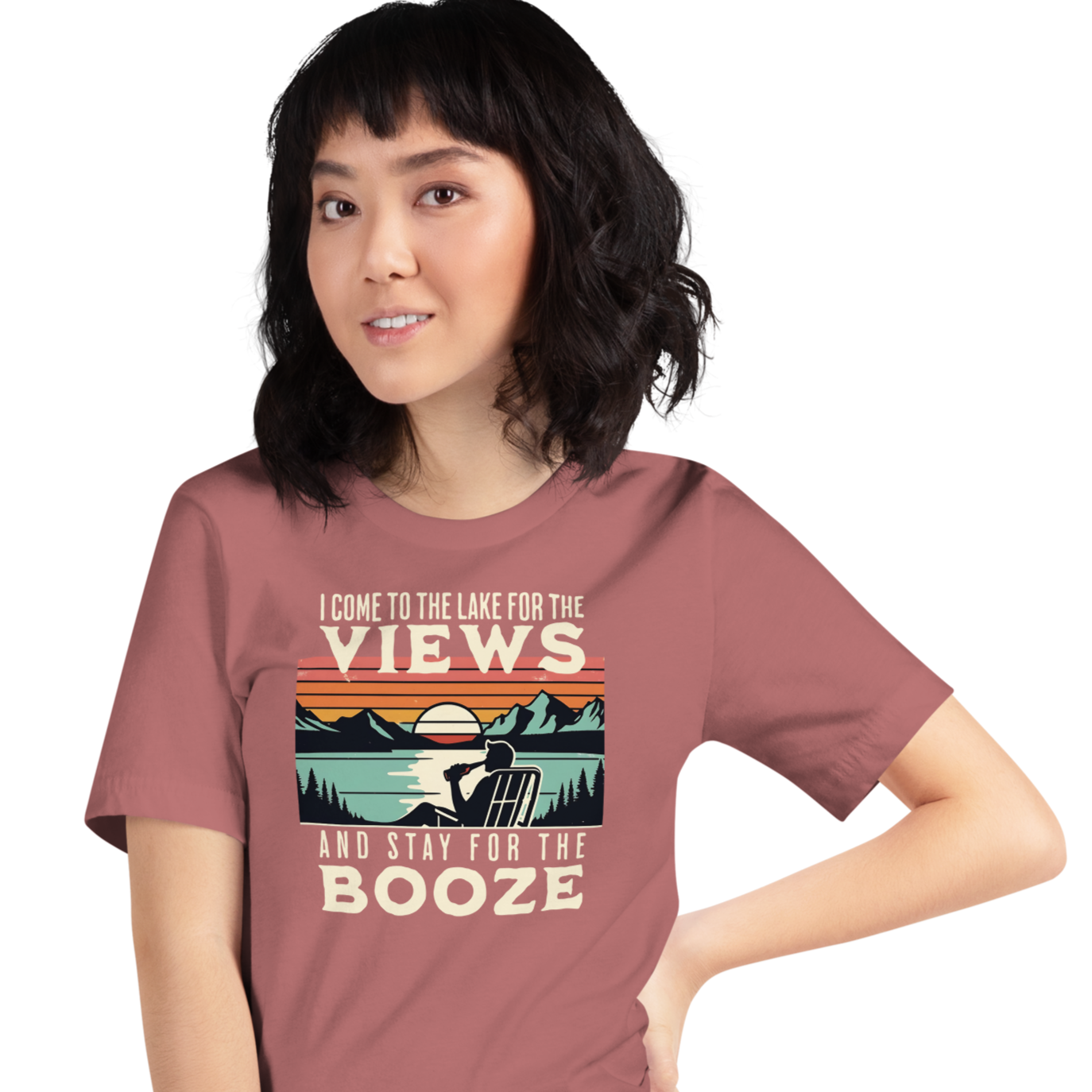 Tee showing "I Come to the Lake for the Views and Stay for the Booze," with a man in a beach chair, lake, and retro sunset.