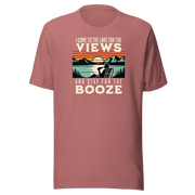 Tee showing "I Come to the Lake for the Views and Stay for the Booze," with a man in a beach chair, lake, and retro sunset.