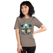 Woman with cocktail on beach on 'Sun, Sand, and a Drink in My Hand' tee, showcasing ocean and sun background