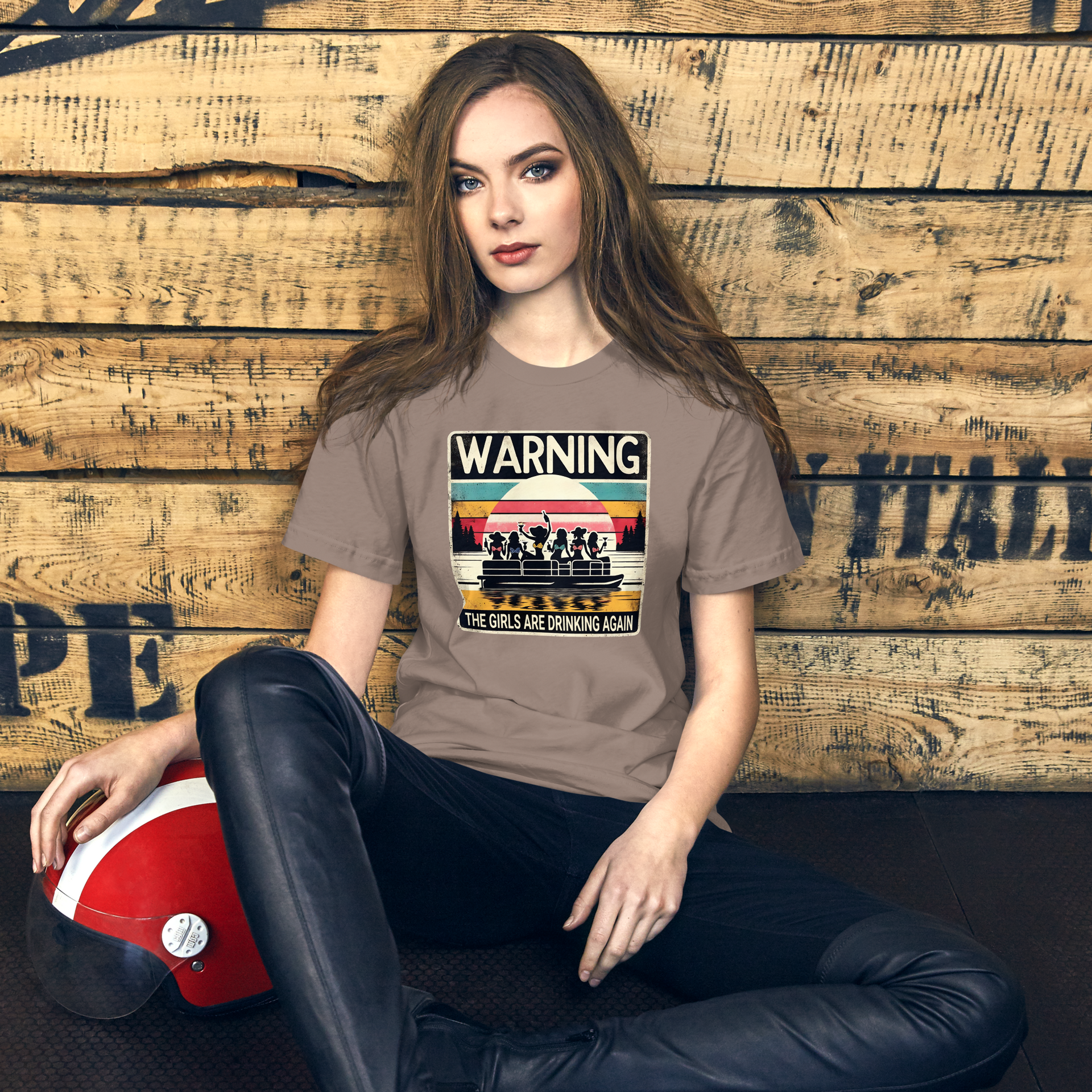 Tee showing "Warning: The Girls Are Drinking Again" with an image of girls on a pontoon boat enjoying drinks at sunset.