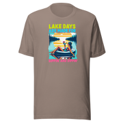 Tee with "Lake Days Are Made for Sipping and Dipping," featuring a woman on a tube float with a cocktail, lake and sunset backdrop.