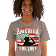 T-shirt with Celebrating America One Shot at a Time text, silhouette of a man drinking a shot, and distressed American flag background. Perfect for 4th of July.