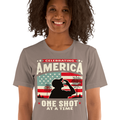 T-shirt with Celebrating America One Shot at a Time text, silhouette of a man drinking a shot, and distressed American flag background. Perfect for 4th of July.