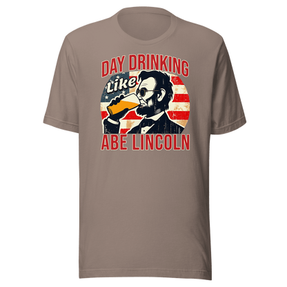 T-shirt with Day Drinking Like Abe Lincoln text, image of Abe Lincoln drinking a glass of beer, and distressed American flag background. Perfect for 4th of July.