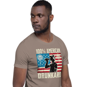 4th of July T-shirt with '100% American Drunkard' text, man drinking a bottle of beer wearing a trucker hat, and distressed American flag background