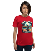 Woman with cocktail on beach on 'Sun, Sand, and a Drink in My Hand' tee, showcasing ocean and sun background