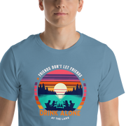 Tee showcasing "Friends Don't Let Friends Drink Alone at the Lake" with a retro sunset and lake scene.