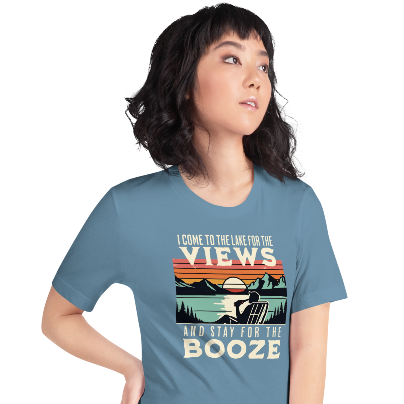 Tee showing "I Come to the Lake for the Views and Stay for the Booze," with a man in a beach chair, lake, and retro sunset.