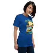 Vintage-inspired 'Tanned and Tipsy' tee with a woman sipping a cocktail on a beach at sunset, perfect for beach drinking and summer parties.