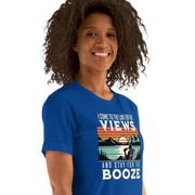 Tee showing "I Come to the Lake for the Views and Stay for the Booze," with a man in a beach chair, lake, and retro sunset.