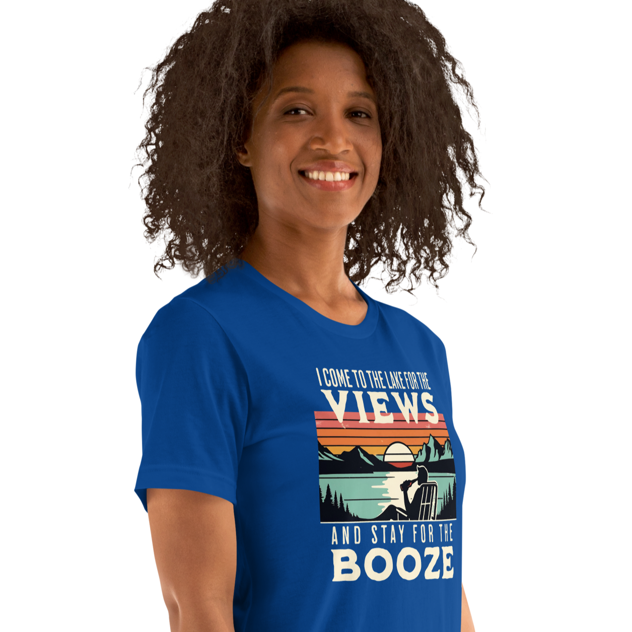 Tee showing "I Come to the Lake for the Views and Stay for the Booze," with a man in a beach chair, lake, and retro sunset.