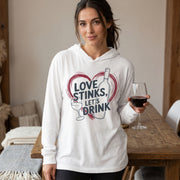 a brunette female model wearing a white featherweight hoodie with the phrase "Love Stinks Let's Drink" surrounded by a sketched valentine's heart and a wine glass and wine bottle