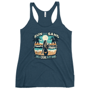 Beach scene on 'Sun, Sand, and a Drink in My Hand' racerback tank, with woman holding cocktail.