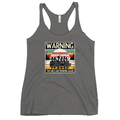 Racerback tank featuring "Warning: The Girls Are Drinking Again" with an illustration of girls drinking on a pontoon boat at sunset.