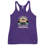 Racerback tank featuring "It's a Good Day to Drink at the Lake with Friends," with people on a boat, lake, and mountains in the background.