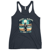 Beach scene on 'Sun, Sand, and a Drink in My Hand' racerback tank, with woman holding cocktail.