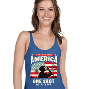 Racerback tank with Celebrating America One Shot at a Time text, silhouette of a man drinking a shot, and distressed American flag background. Perfect for 4th of July.