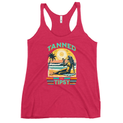 Retro 'Tanned and Tipsy' racerback tank with a woman enjoying a sunset cocktail on the beach, ideal for summer beach parties and day drinking.