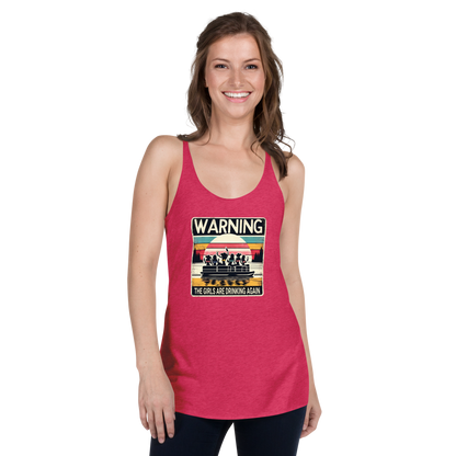 Racerback tank featuring "Warning: The Girls Are Drinking Again" with an illustration of girls drinking on a pontoon boat at sunset.