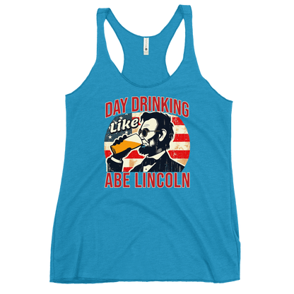 Racerback tank with Day Drinking Like Abe Lincoln text, image of Abe Lincoln drinking a glass of beer, and distressed American flag background. Perfect for 4th of July.