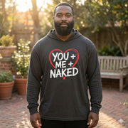 black model wearing black featherweight hoodie with the phrase "You + Me + Naked" with a minimalist sketched valentine's heart surrounding the phrase to complete the design
