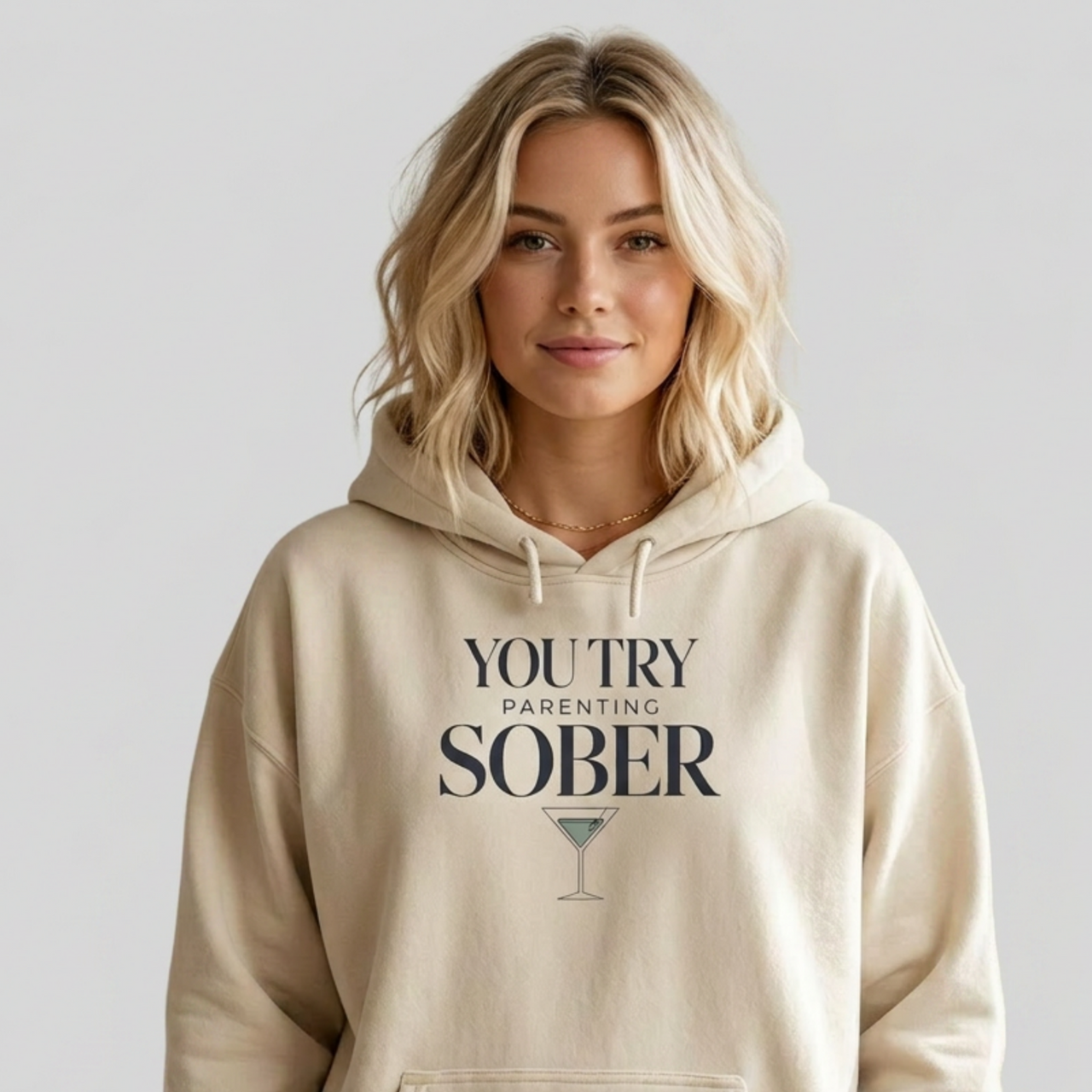 Person wearing a beige hoodie with text 'You try parenting sober' funny mothers day, girls trip, mom life design